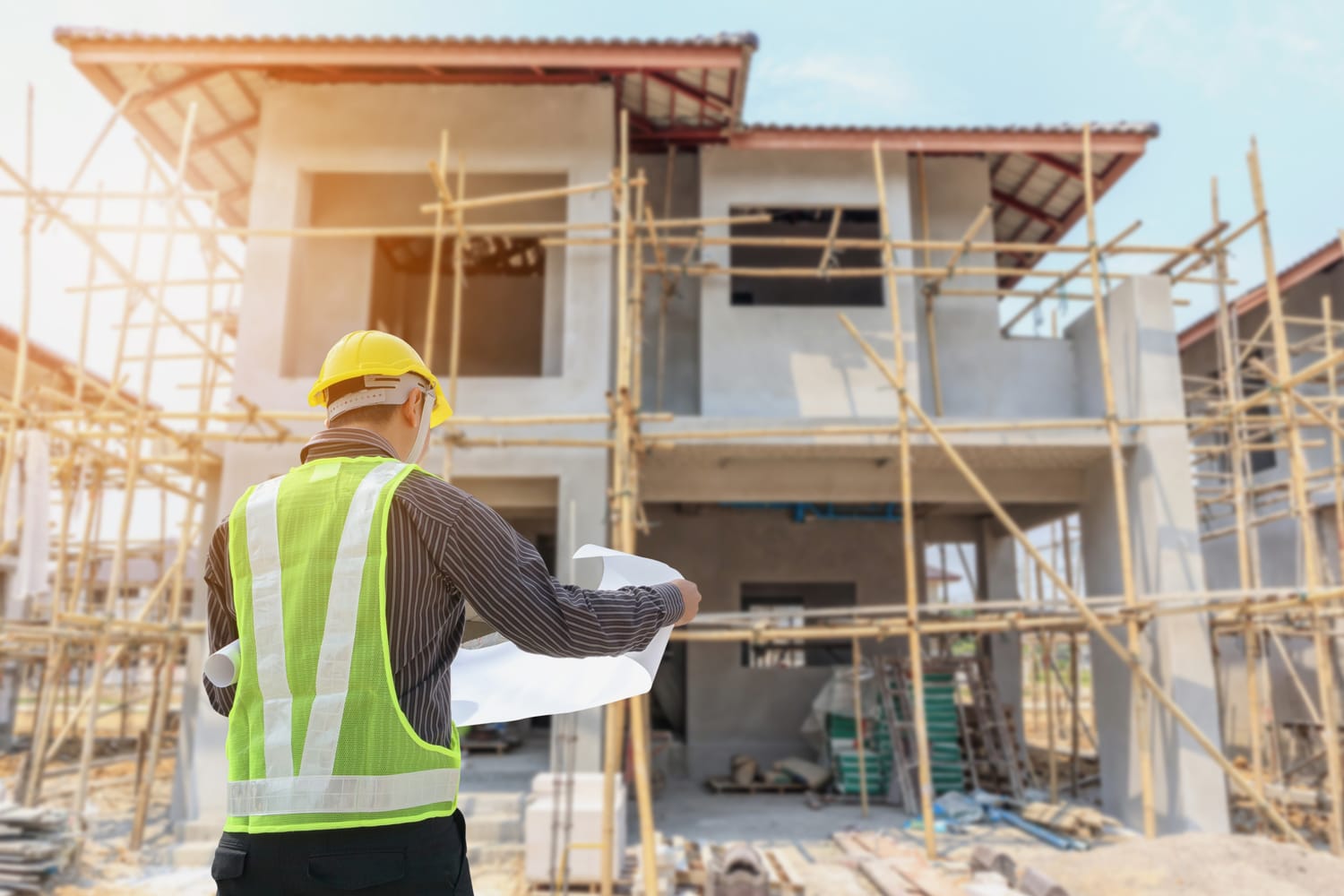 A project manager reviewing plans on a residential construction site